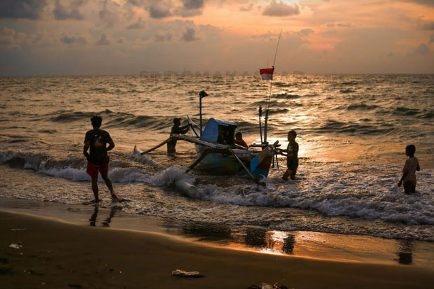 Beberapa nelayan menyiapkan perahu dan alat tangkap di pesisir Pantai Galesong, Takalar, belum lama ini. Mereka masih was-was untuk melaut karena cuaca ektrem. Foto: Sindomakassar/Muchtamir Zaide