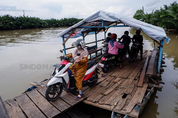 Warga menggunakan jasa perahu penyeberangan di Dermaga Kera-kera sebagai alat transportasi ke Pulau Lakkang, Makassar, Rabu (16/01/2023). Foto: Maman Sukirman