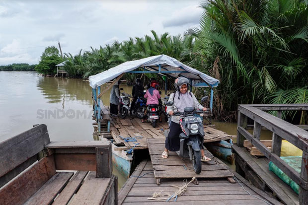 Warga menggunakan jasa perahu penyeberangan di Dermaga Kera-kera sebagai alat transportasi ke Pulau Lakkang, Makassar, Rabu (16/01/2023). Foto: Maman Sukirman