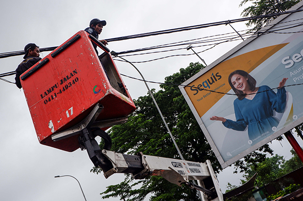 Petugas dari Dinas Pekerjaan Umum (PU) Kota Makassar melakukan penertiban jaringan kabel di Jalan Penghibur.