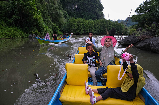 Wisatawan berwisata menggunakan perahu listrik di kawasan Karst Rammang-rammang.