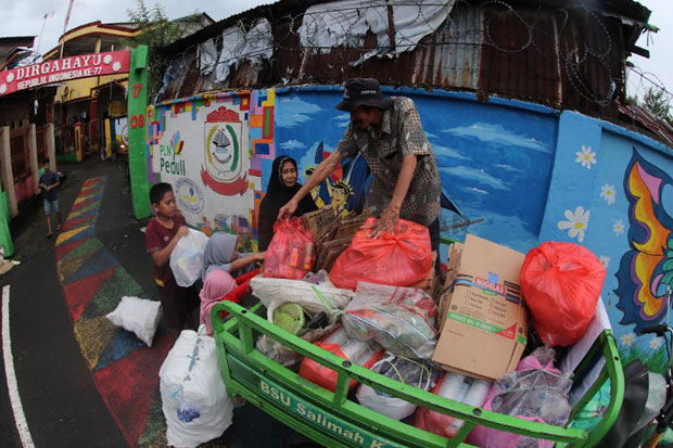 Beberapa warga tengah mengumpulkan smpah untuk dibawa ke Bank Sampah Unit Salimah Karuwisi, Makassar (18/1/2023). Foto: Sindomakassar/Muctamir Zaide