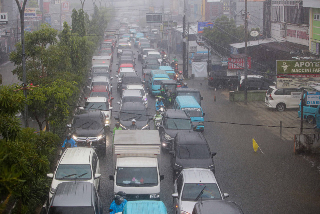 Sejumlah kendaraan menerobos banjir yang menutupi jalan protokol pusat Kota Makassar, (13/2/2023).