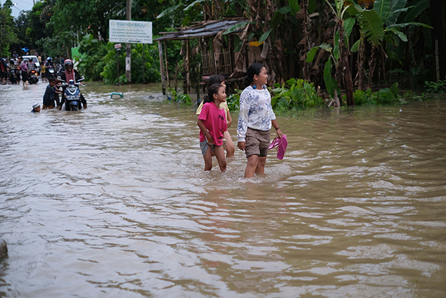 Sejumlah anak bermain di tengah banjir Jalan Nipa-nipa, Makassar.