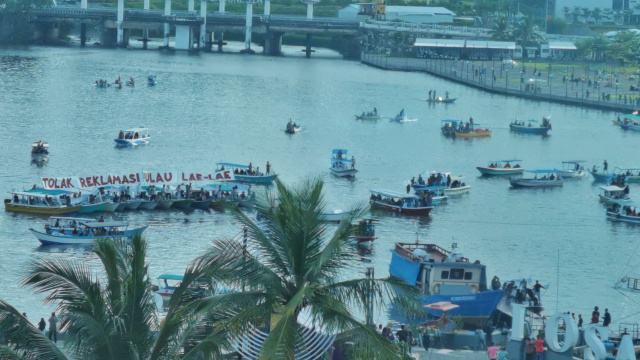 Warga Pulau Lae-Lae menggelar aksi dengan membentangkan spanduk  menolak reklamasi di perairan Pantai Losari.