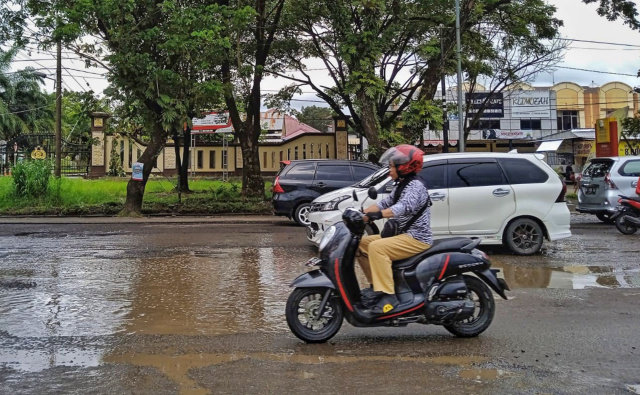 Sejumlah kendaraan melewati genangan air di Jalan Perintis Kemerdekaan KM 16, Makassar, Senin (6/3/2023).