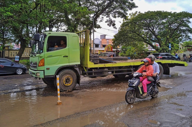 Sejumlah kendaraan melewati genangan air di Jalan Perintis Kemerdekaan KM 16, Makassar, Senin (6/3/2023).