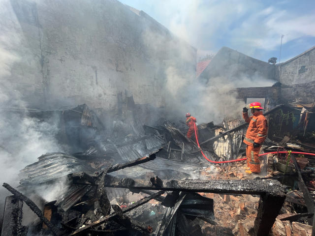 Petugas pemadam kebakaran dibantu warga berusaha memadamkan api yang melalap pemukiman di Jalan Dato Ribandang, Kelurahan Kalukuang, Makassar, Kamis (16/03/2023).