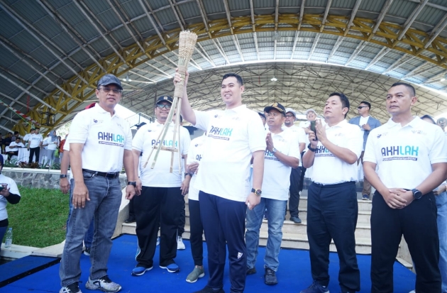 Bupati Pangkep Muhammad Yusran Lalogau memegang obor sebagai simbol pelaksanaan Jalan Sehat Bersama BUMN. Event ini memang mengusung konsep 'Estafet Obor BUMN' dari Sabang sampai Merauke.