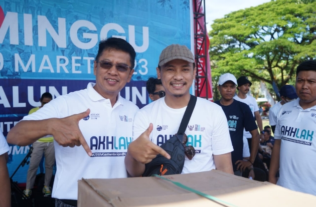 Direktur Operasi PT Semen Tonasa, Mochamad Alvin Zaini berfoto bersama salah seorang warga yang memenangkan doorprize pada acara Jalan Sehat Bersama BUMN di Pangkep.