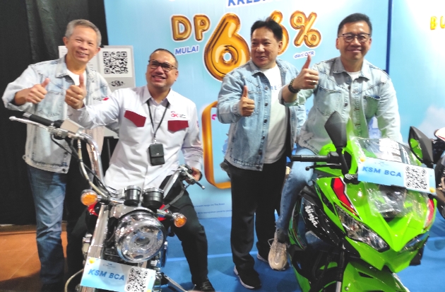 Direktur BCA Haryanto T Budiman dan Deputi Direktur OJK Regional 6 Sulampua Steven Parinussa berfoto bersama sembari mengendarai sepeda motor di salah satu stan BCA Expo Makassar 2023.