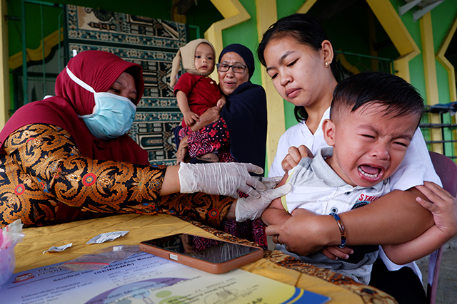 Petugas kesehatan memberikan imunisasi kepada anak di Posyandu Anyelir XI ORW 11, Kelurahan Manggala, Makassar.