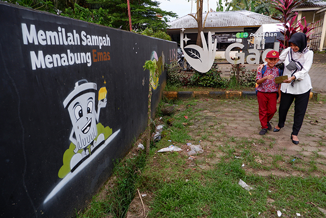 Nasabah bersama anaknya usai menabung emas di Makassar, Sulawesi Selatan, (08/03/2023). PT Pegadaian terus berupaya mengembangkan fitur layanan digital. Adapun pada tahun ini, Pegadaian memiliki fitur baru yang dinamakan Rencana Emas.