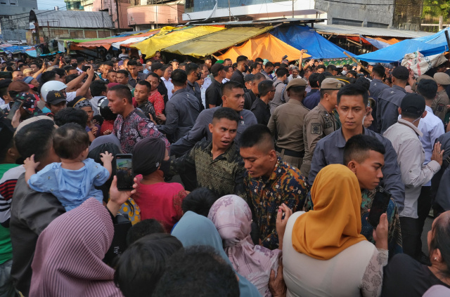 Warga berdesak-desakan menanti kedatangan Presiden Joko Widodo di Pasar Terong, Makassar, Sulawesi Selatan, Rabu (29/3/2023).