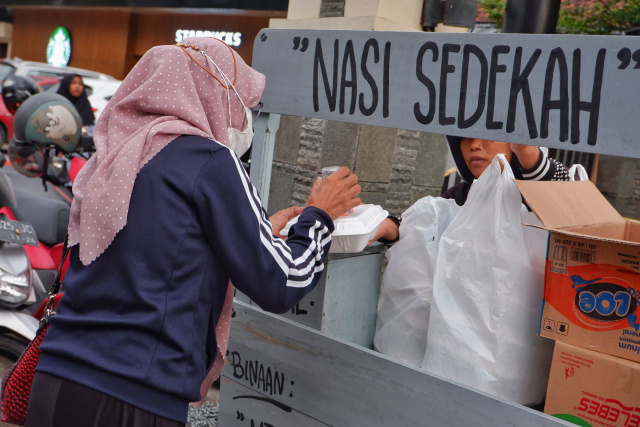 Warga antri mengambil nasi sedekah yang dibuka oleh Majelis Taklim Ummahatul Mukminat di Jalan Karunrung, Makassar, Sabtu (16/4/2023).