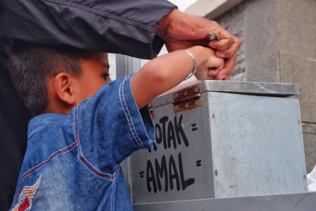 Warga antri mengambil nasi sedekah yang dibuka oleh Majelis Taklim Ummahatul Mukminat di Jalan Karunrung, Makassar, Sabtu (16/4/2023).