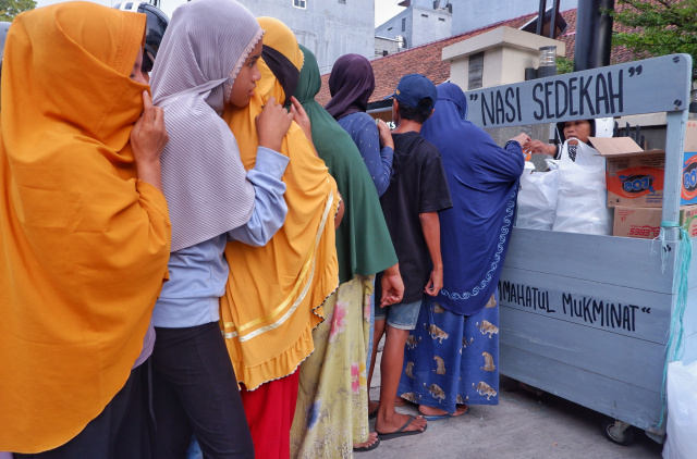 Warga antri mengambil nasi sedekah yang dibuka oleh Majelis Taklim Ummahatul Mukminat di Jalan Karunrung, Makassar, Sabtu (16/4/2023).