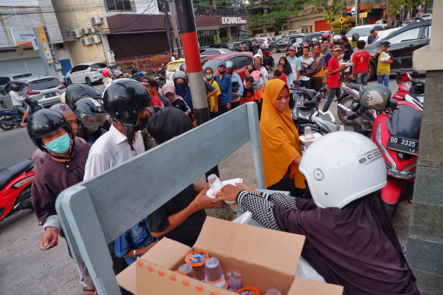 Warga antri mengambil nasi sedekah yang dibuka oleh Majelis Taklim Ummahatul Mukminat di Jalan Karunrung, Makassar, Sabtu (16/4/2023).