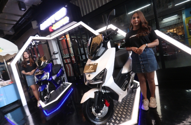 Dua model tampak berpose di samping sepeda motor listrik United E-Motor. Adapun Kalla Kars bertindak sebagai dealer untuk Pulau Sulawesi, sebagian Pulau Jawa dan Pulau Kalimantan.