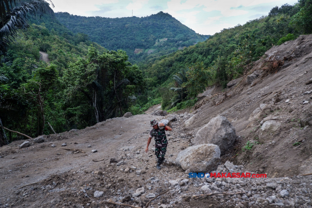 Komandan SSK Kapten Czi Andi Mappawari ikut mengangkat batu dalam pembuatan Talud bersama anggota Satgas di di Desa Gattareng Matinggi, Kecamatan Mallawa, Kabupaten Maros, Minggu (4/6/2023).