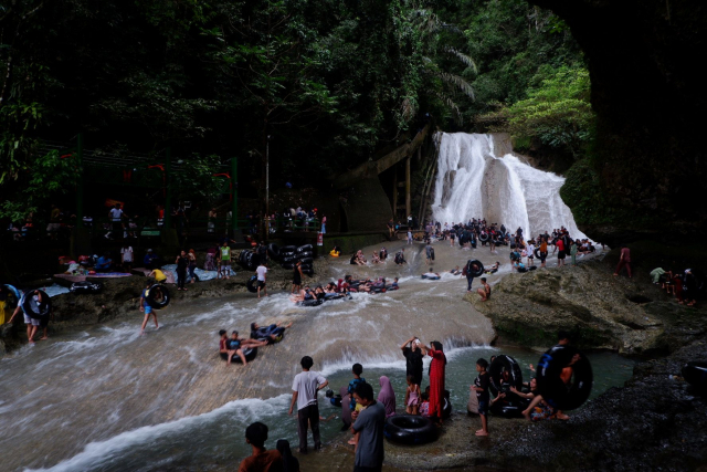 Suasana pengunjung menikmati permandian air terjun Bantimurung, Kabupaten Maros, Sulawesi Selatan, Minggu (2/7/2023).