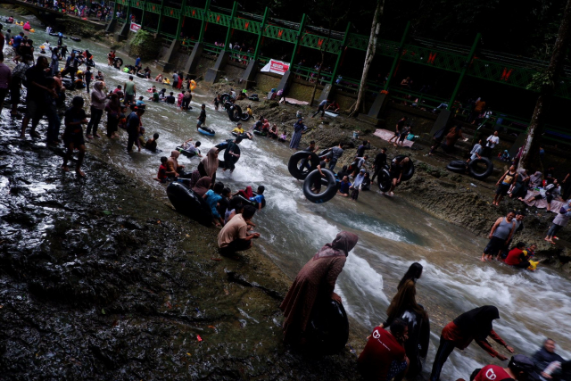 Suasana pengunjung menikmati permandian air terjun Bantimurung, Kabupaten Maros, Sulawesi Selatan, Minggu (2/7/2023).