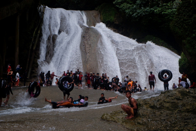 Suasana pengunjung menikmati permandian air terjun Bantimurung, Kabupaten Maros, Sulawesi Selatan, Minggu (2/7/2023).