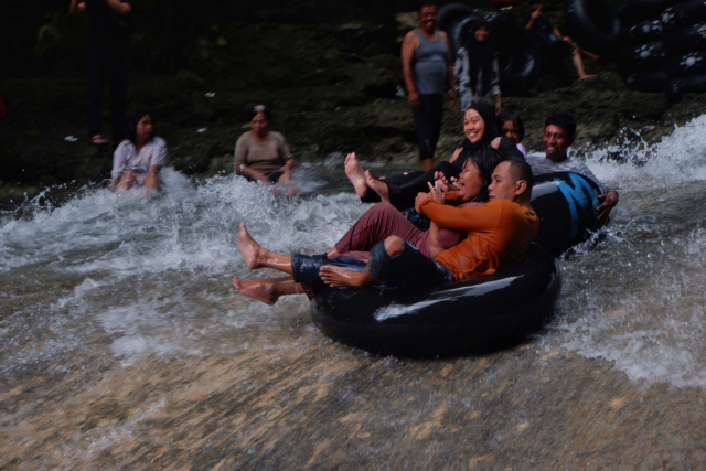 Suasana pengunjung menikmati permandian air terjun Bantimurung, Kabupaten Maros, Sulawesi Selatan, Minggu (2/7/2023).