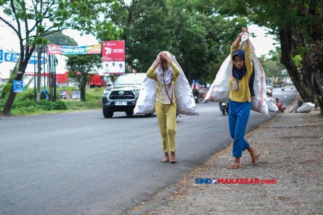 Dua pemulung anak melintas jalan Perintis Kemerdekaan, Makassar, (2/7/2023).