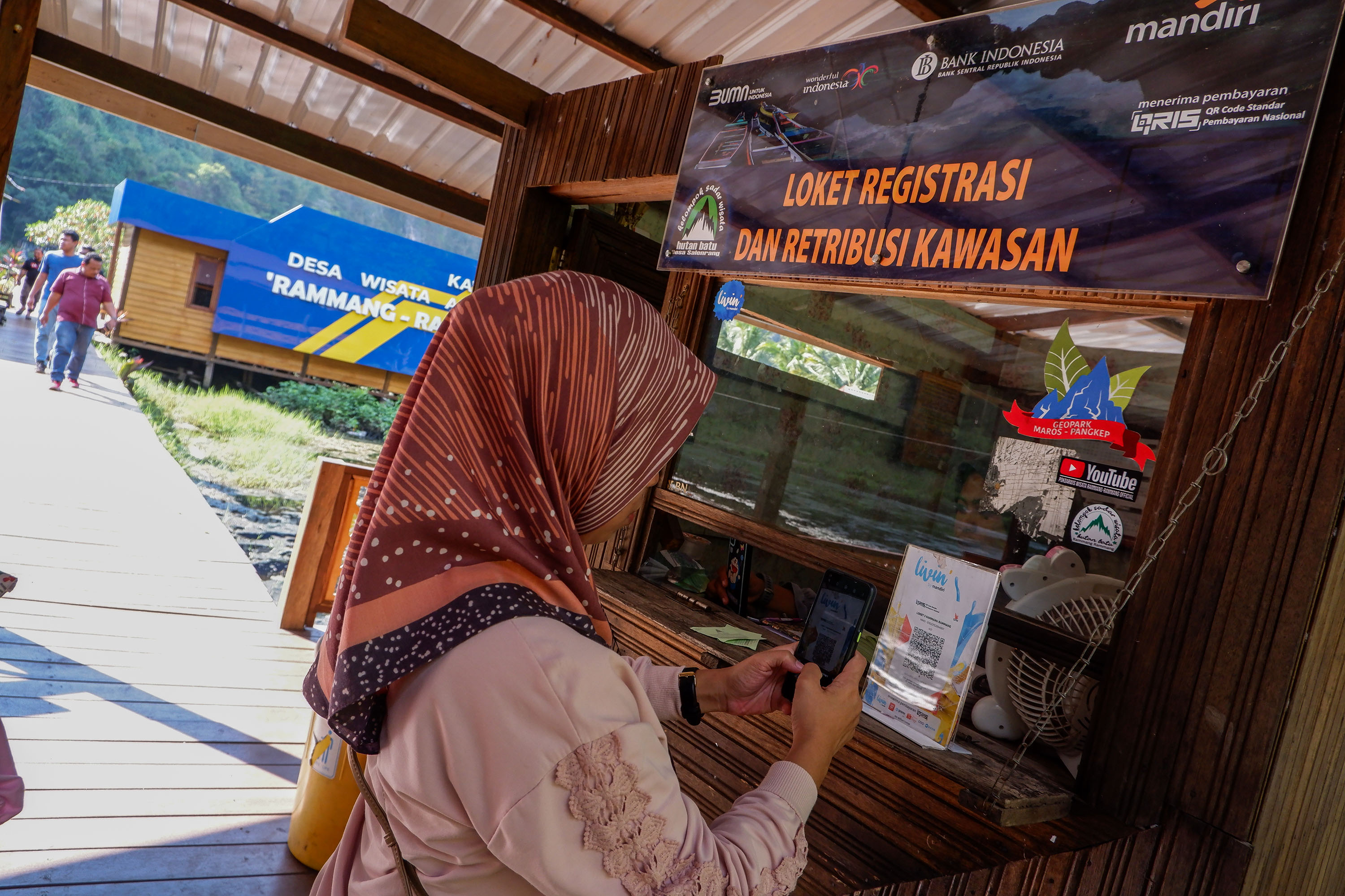 Warga melakukan transaksi pembayaran digital menggunakan scan QR Code di kawasan wisata Kars Rammang-rammang, Maros, (23/7/2023).