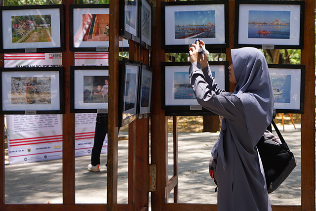 Seorang pengunjung mengabadikan momen di pameran pojok UKM Fotgrafi Unhas  yang bertema “Sequence”  di Taman Pintu 1 Unhas.