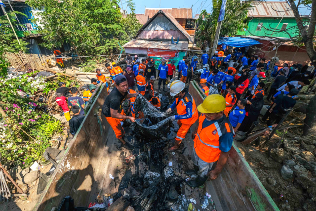 Kelompok pemuda Pandawara Group bersama warga dan petugas kebersihan membersihkan sampah di kampung Nelayan Manggara Bombang, Makassar, Minggu (22/10/2023).