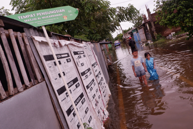 Warga menerobos banjir yang merendam Kompleks Perumnas Antang Blok 10, Makassar, Sulawesi Selatan, Kamis (18/1/2024).