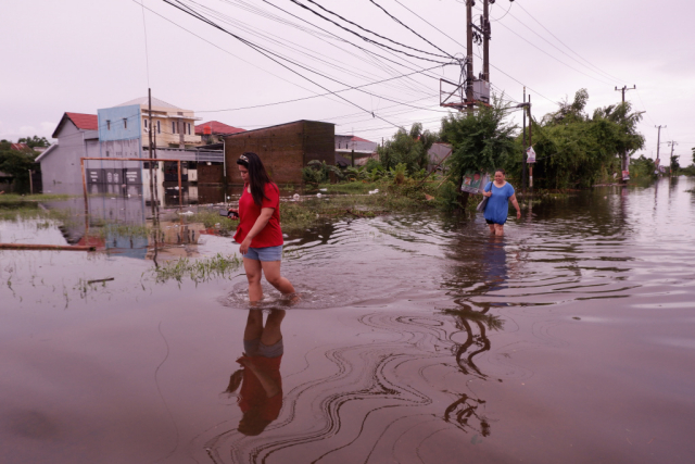 Warga menerobos banjir yang merendam Kompleks Perumnas Antang Blok 10, Makassar, Sulawesi Selatan, Kamis (18/1/2024).