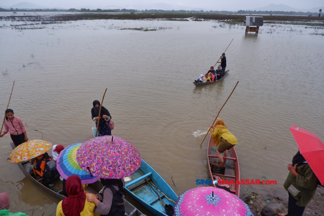 Sejumlah pelajar pulang dari sekolah menggunakan sampan melintasi area persawahan yang terendam banjir di Romang Tangngaya, Manggala, Makassar, Sulawesi Selatan.