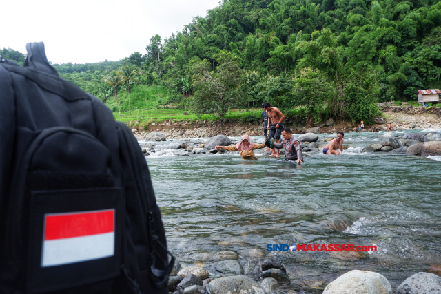 Petugas kepolisian membantu anggota KPPS menyebrang sungai di Desa Bonto Matinggi, Kecamatan Tompobulu, Kabupaten Maros, Sulsel