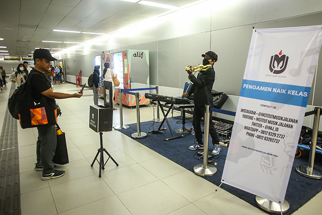 Pengunjung memberikan uang digital lewat Qris dari tabungan Gopay kepada pengamen di  Stasiun MRT Jakarta, Jumat (8/12/2023).  Bank Jago bekerja sama dengan GoPay menawarkan produk tabungan yang diawasi oleh Otoritas Jasa Keuangan (OJK), Bank Indonesia dan Lembaga Penjamin Simpanan (LPS).