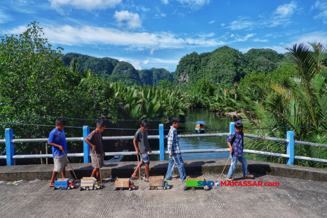 Sekelompok anak bermain truk mainan di kawasan Karst Rammang-rammang, Maros,  Sulawesi Selatan.