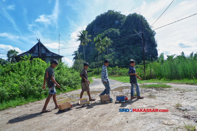 Sekelompok anak bermain truk mainan di kawasan Karst Rammang-rammang, Maros,  Sulawesi Selatan.