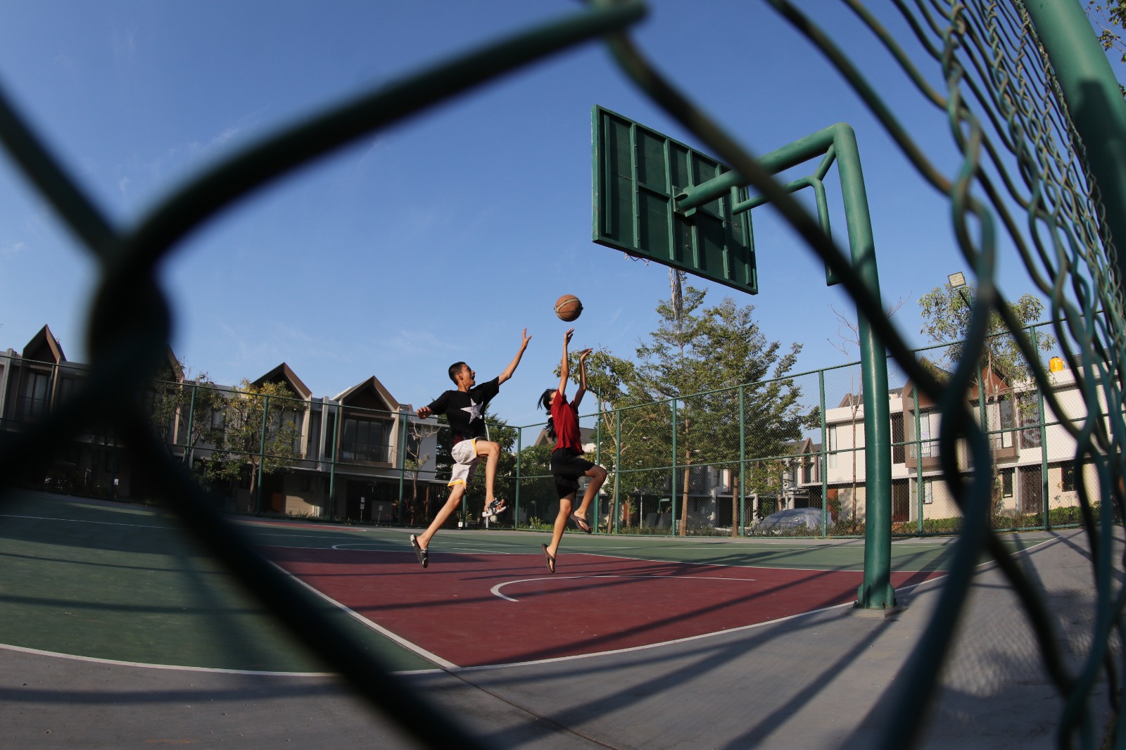 Beberapa pemuda bermain basket di areal perumahan komersial di Kota Makassar, 21 Februari 2024.