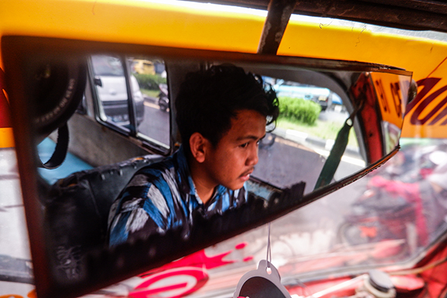 Sopir Pete-pete (angkot) membawa penumpang melewati Jalan Urip Sumoharjo, Makassar.