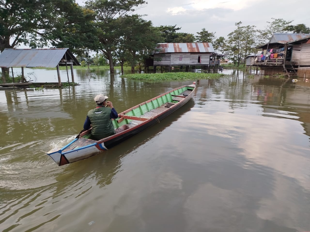 Petugas Pantarlih mendayung perahu melewati banjir saat hendak melakukan Coklit di Kelurahan Wette’e, Kecamatan Panca Lautang, Kabupaten Sidrap. Foto: Dok KPU Sidrap