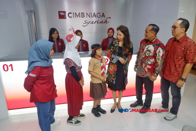 Direktur Compliance, Corporate Affairs & Legal CIMB Niaga Fransiska Oei (ketiga kanan), Head of Region Indonesia Timur Bali Nusa Tenggara CIMB Niaga Ahmad S Ilham (kanan), dan Deputi Direktur Layanan Manajemen Strategis dan Koordinasi Regional Otoritas Jasa Keuangan Sulawesi Selatan dan Sulawesi Barat Bondan Kusuma (kedua kanan) memberikan penjelasan kepada siswa sekolah dasar yang melakukan Tour de Bank di Bank CIMB Niaga Syariah Makassar, Sabtu (27/7/2024).