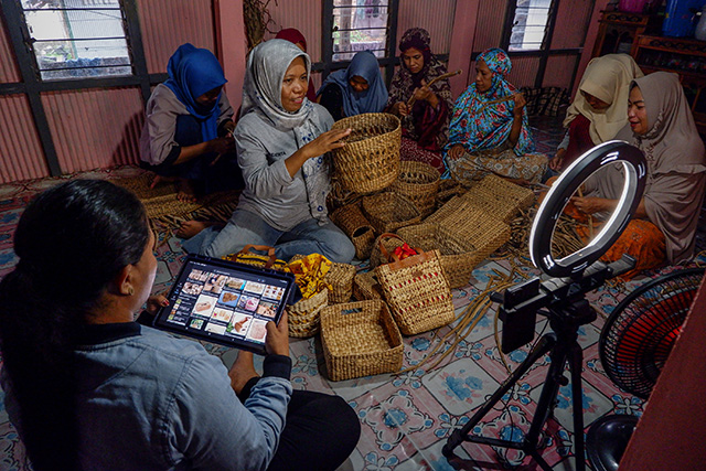 Surianty ketua kelompok UMKM Bungaeja Craf bersama beberapa pekerja perempuan membuat kerajinan tangan dari bahan baku eceng gondok dan memasarkan langsung produknya secara online di Desa Damai, Kecamatan Tanralili, Kabupaten Maros, Rabu (13/12/2023). Bank Rakyat Indonesia (Persero) Tbk. (BRI) sebagai bank yang memiliki fokus bisnis pada segmen Usaha Mikro, Kecil dan Menengah (UMKM) memiliki target pencapaian 90% dari inklusi keuangan tahun 2025. Porsi pinjaman untuk UMKM targetnya mencapai 85 persen. Terjadi peningkatan Holding Ultra Mikro dalam meningkatkan inklusi keuangan, dan pemberdayaan perempuan.