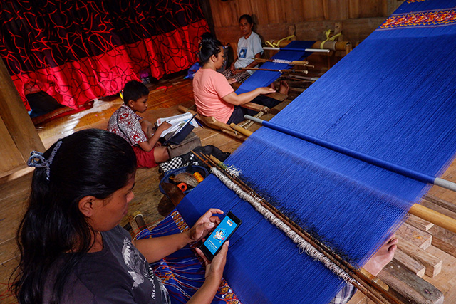 Pengrajin tenun mengakases BRILink Mobile di Dusun Lembang, Desa Sa'dan Andulan, Kecamatan Sa'dang, Kabupaten Toraja Utara, Sulawesi Selatan, Rabu (4/9/2024). Di tengah semangat untuk mendukung pertumbuhan UMKM di Toraja Utara, Bank Rakyat Indonesia (BRI) telah mengambil langkah konkret dengan memperkenalkan layanan BRILink Mobile.