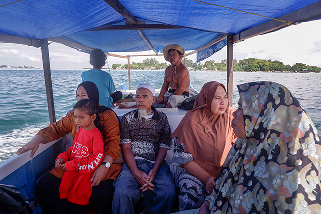 Sattuan (61 tahun) bersama kerabatnya menggunakan perahu menuju daratan Kabupaten Pangkep.