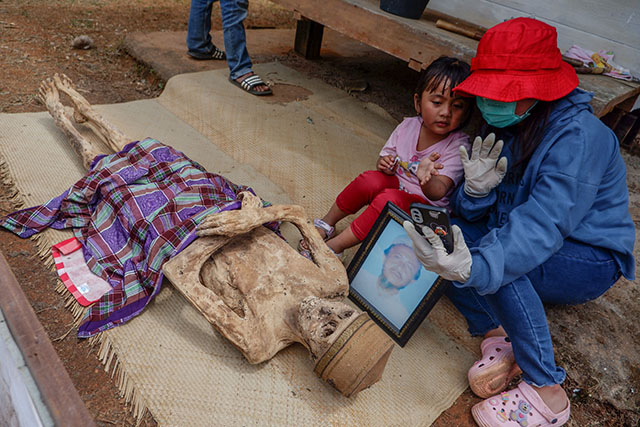 Warga melakukan live streaming menggunakan smartphone untuk mengabari kerabatnya yang tidak sempat hadiri pada ritual Ma'Nene di Desa Lembang, Kabupaten Toraja Utara, Sulawesi Selatan.