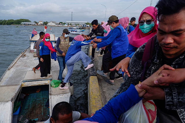 Tim Perahu Sehat Pulau Bahagia berusaha naik diatas pelabuhan untuk melakukan pemeriksaan kesehatan gratis kepada masyarakat.