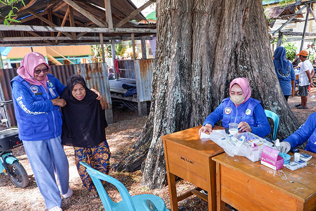 Kepala Puskesmas Sabutung, Harmawati,S.Kep,Ns, membantu warga lansia menuju tempat pemeriksaan kesehatan.