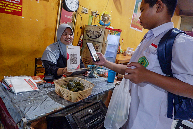 Pengunjung melakukan transaksi pembayaran menggunakan QRIS di Warung Coto Makassar.